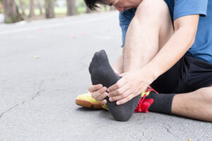 Male runner clutching his painful foot
