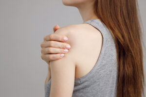 Female athlete clutching her painful shoulder