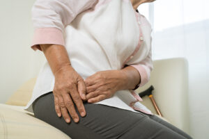 Elderly woman rubbing her painful hip