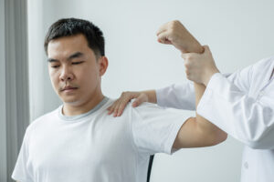 Medical professional examining a patient's painful shoulder