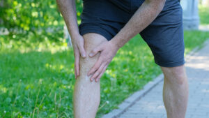 Male runner holding his painful knee