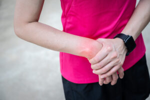 Close-up of athletic woman holding her painful wrist