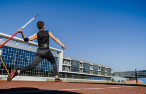 Male athlete throwing a javelin at a track and field competition
